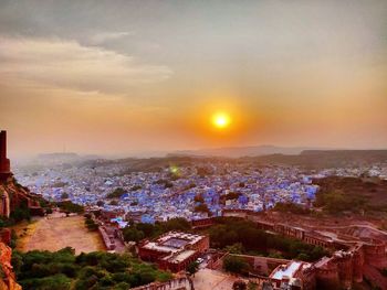 High angle shot of townscape against sky at sunset