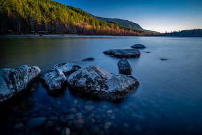 Rocks in lake against sky