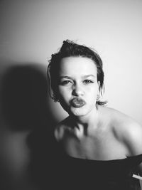 Portrait of young woman against gray background