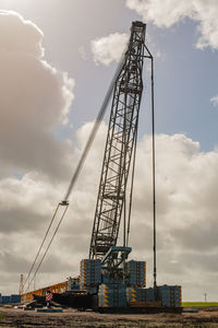 Low angle view of crane against sky