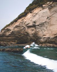 Rock formations by sea against sky