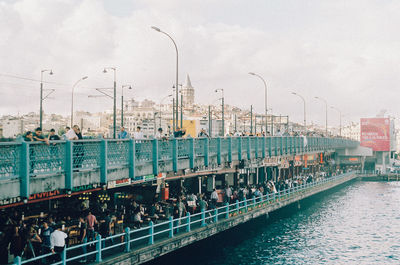 People standing on galata bridge over river
