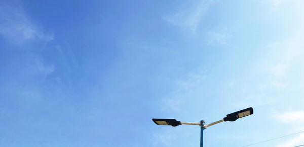 Low angle view of street light against blue sky