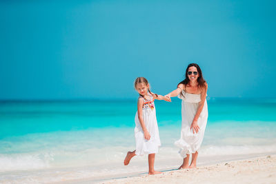 Full length of woman standing on beach against sea