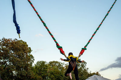Low angle view of multi colored hanging on rope against sky