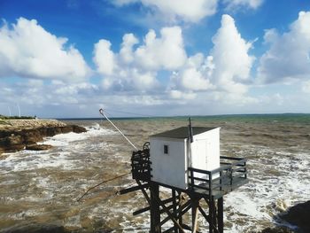 Lifeguard hut on beach against sky