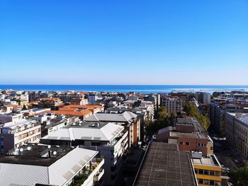 High angle view of townscape by sea against clear sky