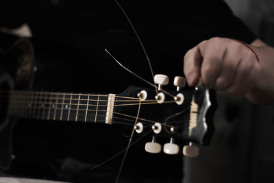 Midsection of man holding guitar