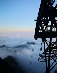 Low angle view of silhouette crane against sky during sunset