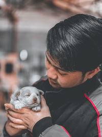 Midsection of man holding small dog