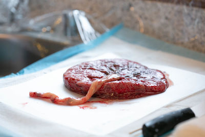 Human placenta lying on white pad on countertop visible umbilical cord