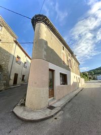 Old building by road against sky