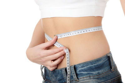 Midsection of woman standing against white background