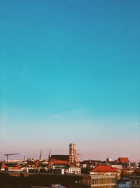 Buildings in city against clear blue sky