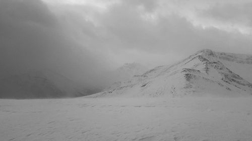 Scenic view of mountains against cloudy sky