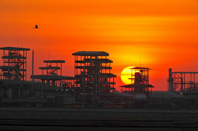 Silhouette of buildings against orange sky