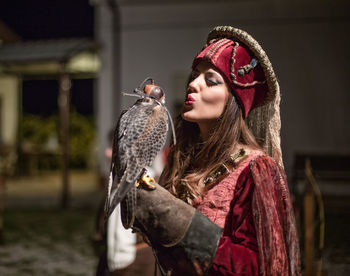 Portrait of young woman holding mask outdoors