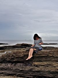 Woman at beach against sky