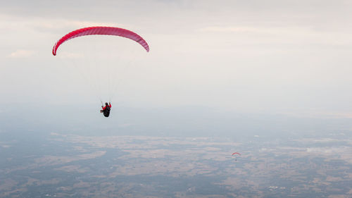 Person paragliding against sky