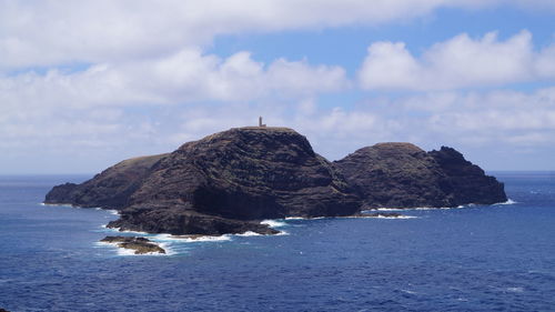 Rock formation in sea against sky