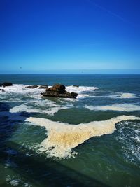 Scenic view of sea against clear blue sky