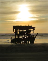 Silhouette pier on sea against sky during sunset