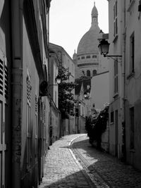 Empty street amidst buildings leading towards basilique du sacre coeur