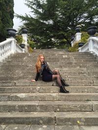 Fashionable woman sitting on staircase