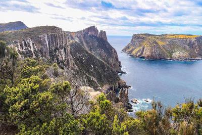 Scenic view of sea and mountains against sky