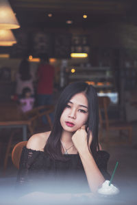 Portrait of beautiful young woman sitting in cafe