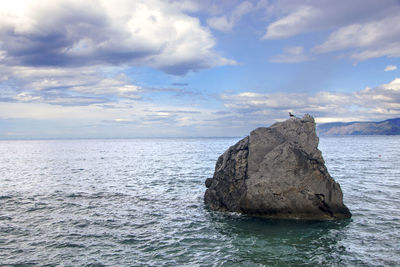 Rocks in sea against sky