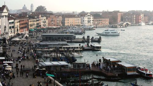 Boats in sea with buildings in background