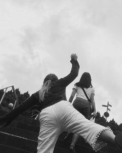 Rear view of people sitting against sky