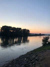 Scenic view of lake against clear sky at sunset