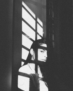 Portrait of young man standing against wall