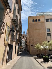 Street amidst buildings against sky in city