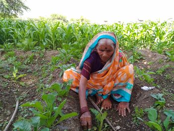 Senior woman harvesting plants at farm