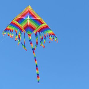 Low angle view of colorful balloons against clear blue sky