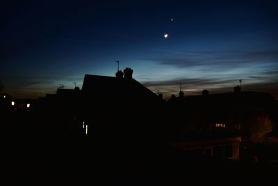 Low angle view of buildings against sky at night