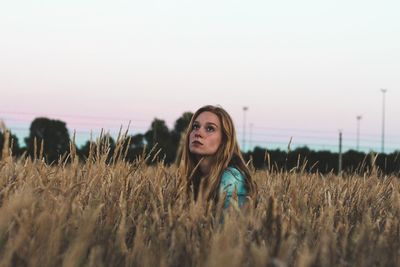 Portrait of woman standing on field against clear sky