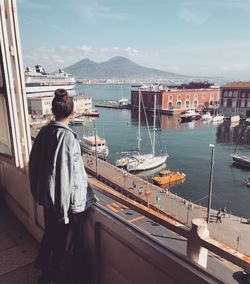 Woman standing against harbor in city