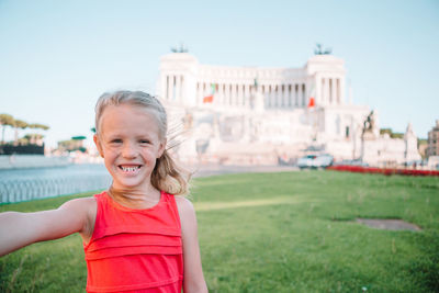 Portrait of smiling girl against built structure