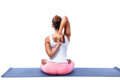 Woman sitting on floor against white background