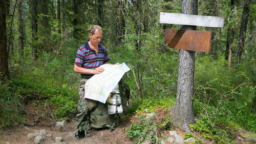 Woman holding umbrella in forest