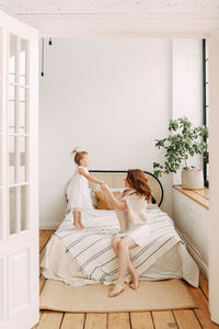 Happy mom and little daughter baby relax unwind and play in a cozy room in a cozy house