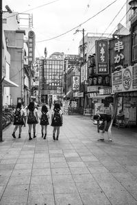 Rear view of people walking on road