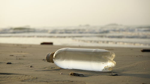 Close-up of garbage bottle on beach