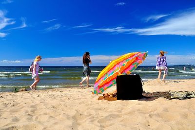 People at beach against sky