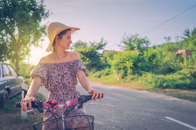 Young woman riding bicycle on road