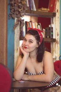 Portrait of young woman sitting on table